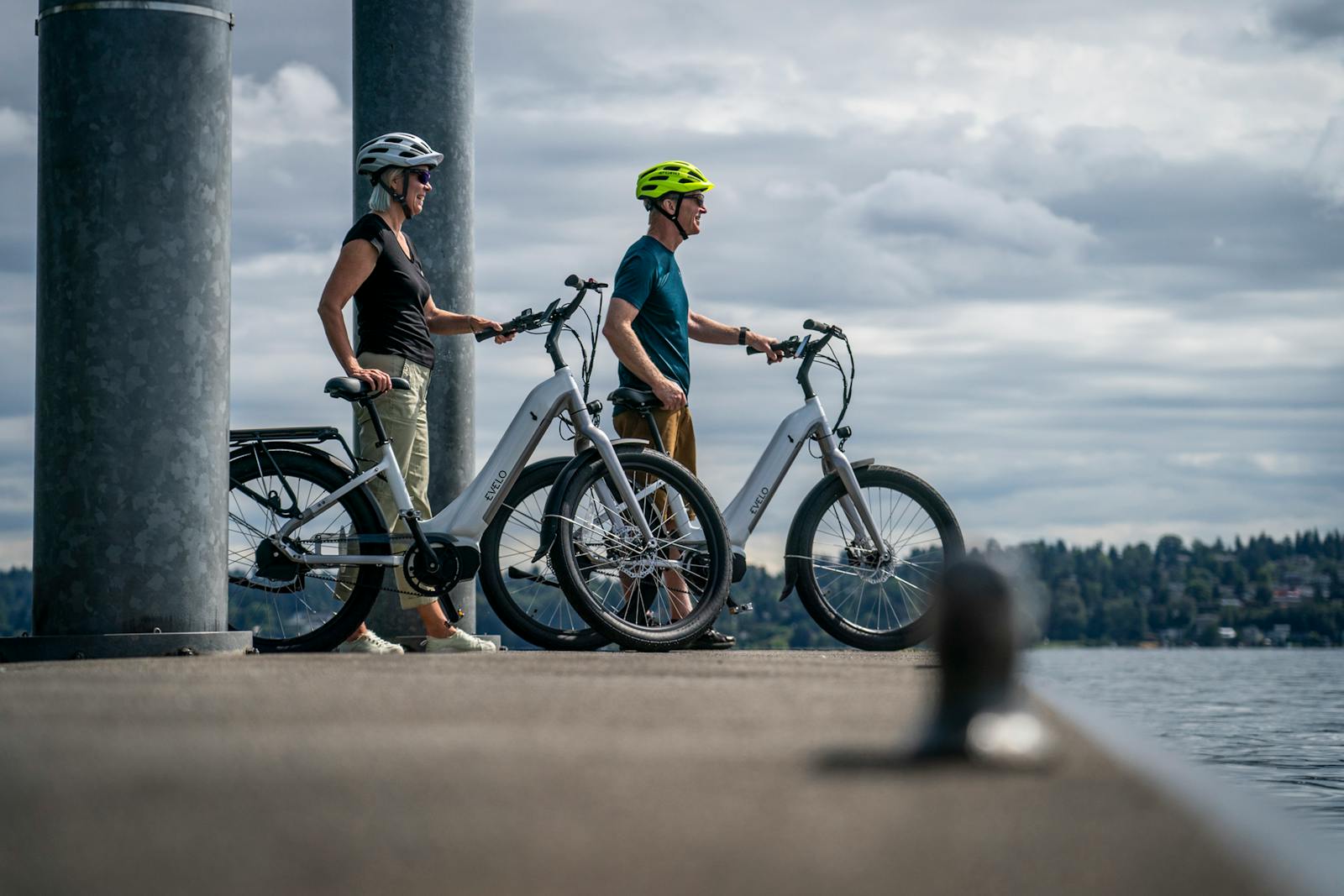 A Couple Standing on Pier Beside Electric Bikes